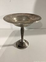 Side view of the weighted sterling silver compote dish showing the bowl, stem, and rounded weighted base with visible tarnish and patina.