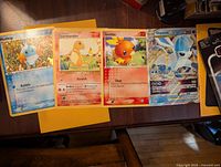 Four oversized Pokémon cards laid flat: Mudkip, Charmander, Torchic, and Glaceon VSTAR, showing front artwork and text.