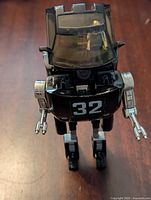 Front close-up of Go Bot 32 figure showing robot head with transparent yellow windshield, arms and legs, and number 32 on chest.