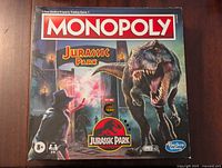 Front of the Monopoly box featuring Jurassic Park artwork with a T-Rex and characters, indicating it plays sound.