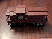 Lionel Lines CNR caboose side view showing brown body, roof structure, and CNR Canada emblem.