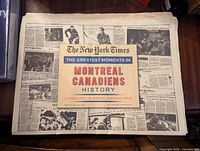 Full open view of the newspaper compilation with the cover and some inside historic newspaper pages showing images and text about Montreal Canadiens history.