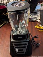 Oster blender viewed from above highlighting glass jar and black lid with removable center cap.