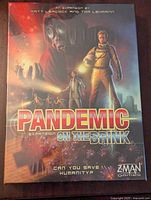 Closed box of Pandemic On the Brink expansion with cover art showing characters in protective suits and gas masks.