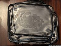 Clear plastic expandable organizer with black edges shown from the top, displaying compartments inside.