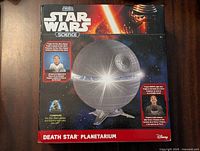 Front of the box showing the Death Star shaped planetarium with Star Wars branding and key features.