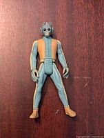 Front view of Star Wars Greedo action figure showing detailed face, blue and beige outfit, boots, and gloves.