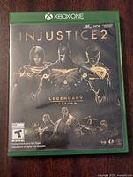 Front cover of the Xbox One game case for Injustice 2 Legendary Edition showing Batman, Superman, and Wonder Woman.