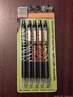 Front view of the unopened retail package holding five Zebra Z Grip retractable ballpoint pens with assorted animal print barrels