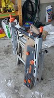 Folded portable Black & Decker Workmate 225 workbench showing frame, clamps, and wooden panels.