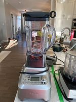 Front view of the Breville Boss blender including clear pitcher with lid and silver base in kitchen environment.