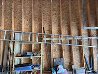 Full view of the 24-foot aluminum extension ladder extended horizontally against a wooden wall.