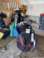 Full view of Ogio golf bag filled with left handed golf clubs and accessories including head covers and small attached bags.