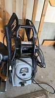 Overall view of the Sundance electric power washer including hose reel and attached hose and spray wand.