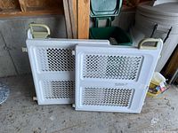 Two Safety 1st safety gates stacked with beige handle visible on one gate.