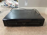 Front view showing Sony logo, power and playback buttons, disc slots, and digital display of the CD player.