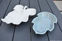 White Hull leaf pottery dish with detailed leaf veins and curled stem, displayed on dark surface.