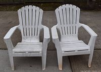Pair of white plastic Adirondack chairs side by side showing overall condition and structure