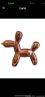 Front angled photo showing the pink metallic balloon dog figurine with reflective surface and balloon animal shape.