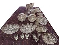 Wide-angle image showing the entire 22-piece vintage Bohemian lead crystal set, arranged on a table with detailed patterns visible on each piece.
