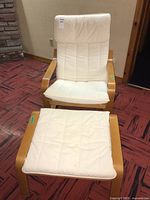 Ikea chair with cream removable cushion seating on light wood curved frame, viewed from the front