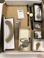 Full view of lot contents showing costume jewelry including watches, necklace, pendants, earrings, and souvenir spoon.
