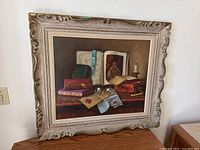 Full view of framed painting leaning against wall