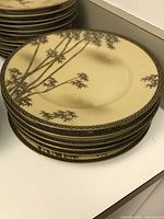 Stack of dinner-sized plates with beige background and bamboo motif