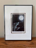 Full view of the framed print showing the wolves, moon, and signature under glass.