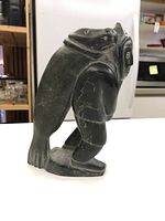 Side view of soapstone carving showing the seal on hunter's back and side posture.