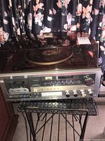 Full view of vintage Lloyd's stereo system with turntable and cassette deck on vintage metal stand, showing entire setup including record holder.