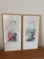 Two framed Yoshihisa prints side by side, glass covered with some surface marks.
