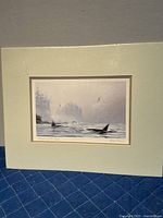 Front view of the print mounted on mat board, showing orca fins in a misty seascape with forest background and seagulls above water.