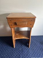 Front view of the maple nightstand showing the drawer and bottom shelf with wear on surface.