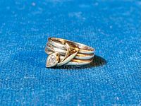 Close-up angle of the ring showing the CZ stone and gold accent over triple silver bands