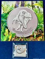 Front view of the 2016 Tyrannosaurus Rex silver coin with background showing a forest scene.