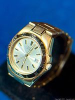 Photo of the Citizen Quartz gold tone men's watch showing the side angle with visible date display and Roman numeral bezel.