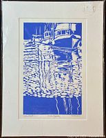 Full view of the framed white matte with blue and white print showing boats and their reflections.