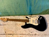 Full view of the Renegade black electric guitar with white pickguard showing entire instrument.