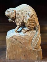 Front three-quarter view of carved beaver on block, showing signature on front.