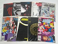 Top-down view of the 10 comics laid out in two rows, visible titles show Marvel's Wonder Man and Shadowhawk among others, all in plastic sleeves with backing boards to protect covers.