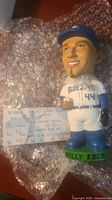 Front view of Billy Koch bobblehead with game ticket on bubble wrap background.