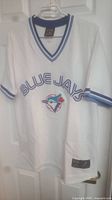 Front view of the white Toronto Blue Jays jersey with blue accents, team name, and logo visible.