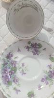 Top view of teacup inside showing "February" text and violet floral pattern on saucer beneath.