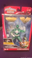 Front view of the Power Rangers Super Megaforce Armored Mighty Morphin Green Ranger action figure in original packaging showing figure and accessories.