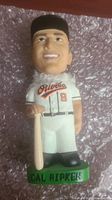Front view of Cal Ripken bobblehead in Orioles uniform standing on a green base saying 'Cal Ripken'.