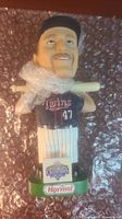 Front view of the Minnesota Twins Todd Koskie bobblehead in uniform with bat over the shoulders and green base with sponsors.