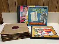 Photo showing stacks of assorted 78 RPM records along with two vintage record albums, including The Glenn Miller Story.