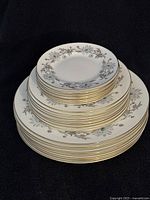 Stacked plates showing three sizes: dinner, salad, dessert plates with floral pattern and gold rims.