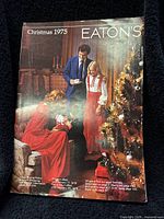 Front cover of Eaton's Christmas 1975 catalog showing three people by a decorated Christmas tree in a cozy interior setting.